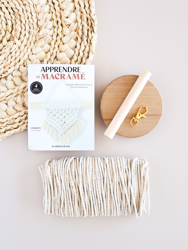 Kit pour apprendre le macramé avec corde en coton, support en bois, mousqueton et livre explicatif proposant des projets de macramé pas à pas.