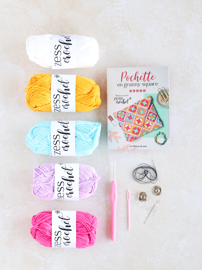 Kit crochet Pochette en granny square de Zess Crochet avec pelotes de coton colorées, crochet, boutons pression et livret explicatif pour réaliser une pochette en carrés granny.