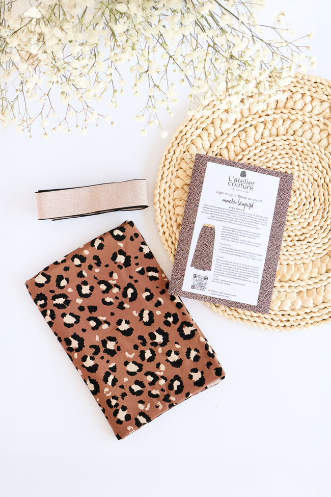 Kit couture avec tissu imprimé léopard, fermeture à glissière et fiche explicative pour réaliser une pochette zippée en tissu.