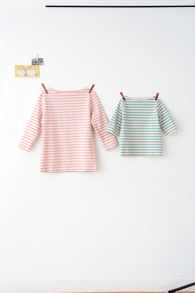 Deux marinières enfant à manches longues rayées rose et vert suspendues sur cintres, modèles de couture DIY idéaux pour confection de vêtements enfants et garde-robe faite main.