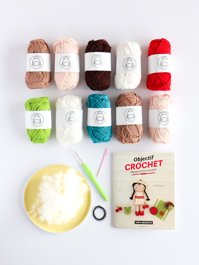 Kit Objectif Crochet Ma première poupée Lulu Compotine avec pelotes de coton colorées, crochet, rembourrage et livre explicatif pour réaliser une poupée au crochet.