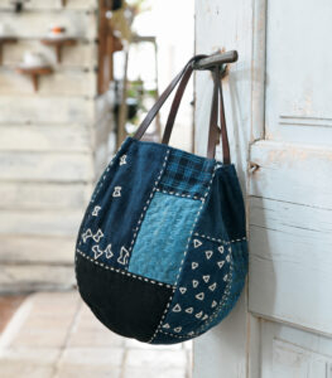 Sac patchwork en denim recyclé suspendu à une porte, accessoire mode upcycling fait main, idéal pour couture DIY, recyclage textile et style artisanal
