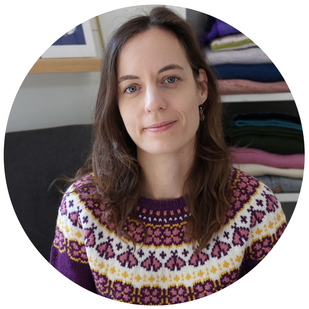 Portrait d’une créatrice portant un pull en tricot jacquard aux motifs colorés dans des tons violet, jaune et écru