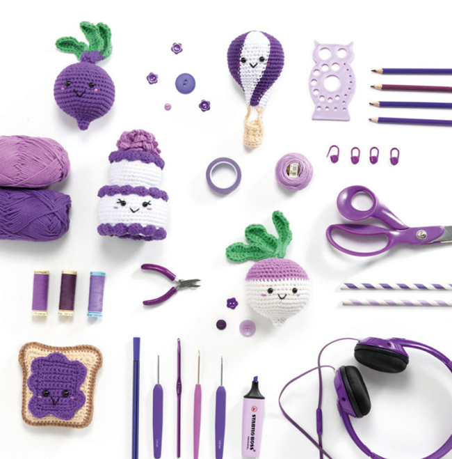 Kit crochet aux nuances violettes mettant en scène amigurumis de légumes et gourmandises, entourés d’outils de crochet et d’accessoires créatifs, idéal pour apprendre le crochet et réaliser des créations handmade originales.
