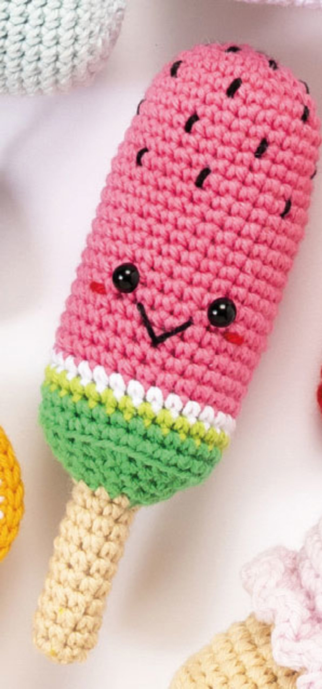 Amigurumi en forme de bâtonnet glacé à la pastèque crocheté à la main, avec visage kawaii brodé et couleurs vives rose, vert et beige, idéal pour crochet DIY, créations gourmandes, univers enfantin et loisirs créatifs handmade.
